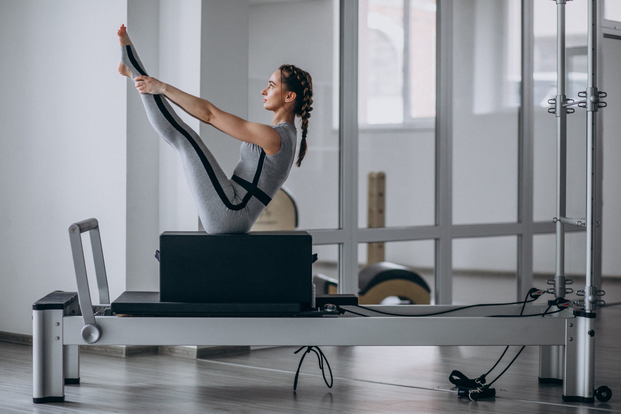 woman practising pilates pilates reformer min scaled